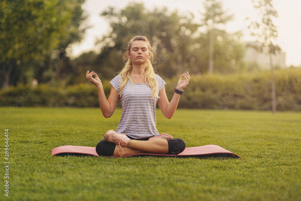 Young Woman practicing yoga pose at the city park at sunset - Concept for Yoga Sport and Healthy lifestyle Young Woman practicing yoga pose at the city park at sunset - Concept for Yoga Sport and Healthy lifestyle