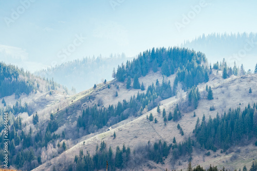 Foggy hills and gloomy mood of the scene of the alpine valley.