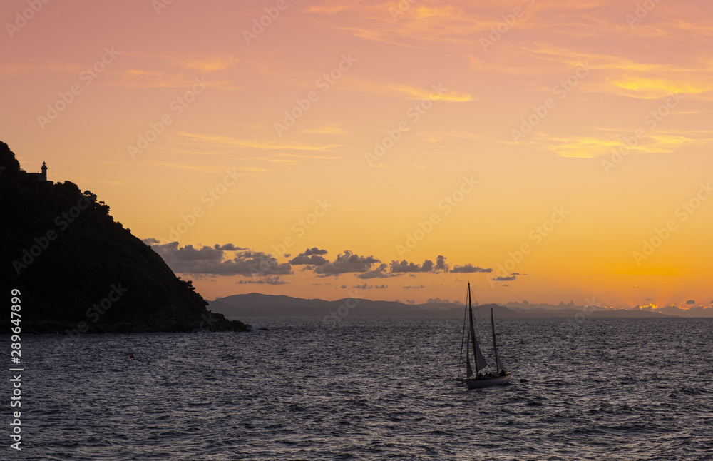 Sailboat on the coast of the city of Donostia with the last rays of the sun at sunset, Cantabrico Sea, Euskadi