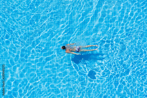 Man under water in hotel swimming pool.