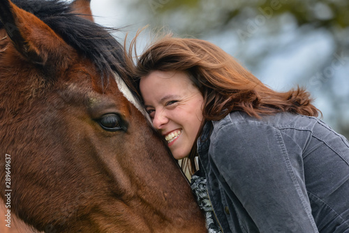 Young woman having a hug with her horse. 