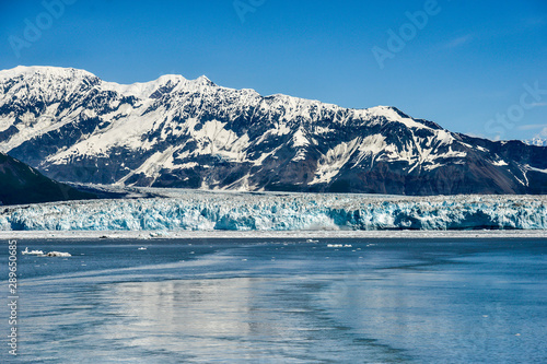 Hubbard Glacier with blue sky and mountains behind it  on a glorious summers day.