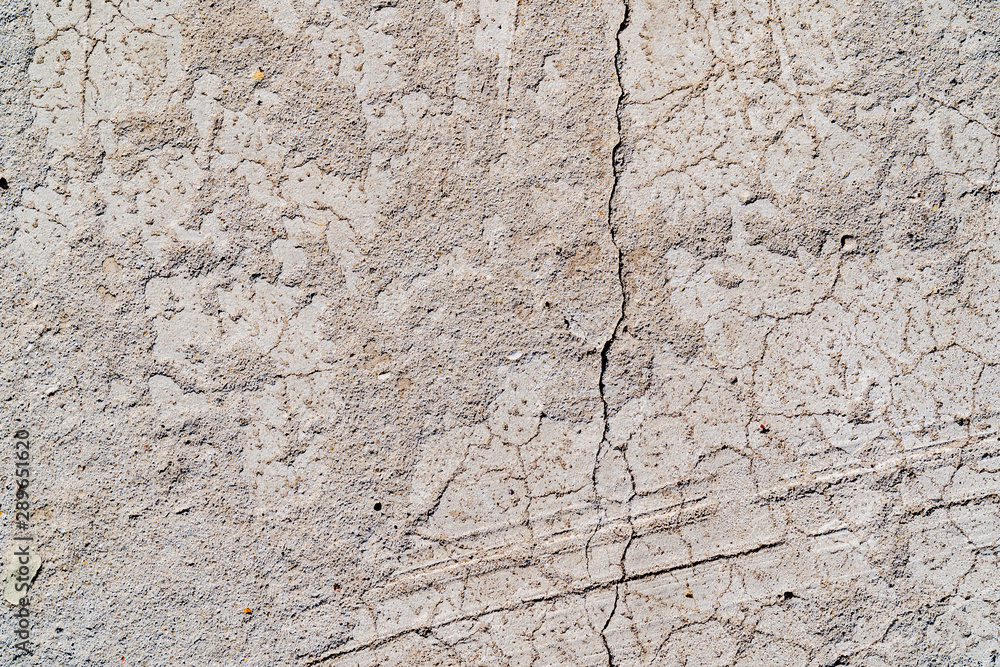 The texture of a concrete wall. Surface with scratches, scuffs, cracks. Gray color of surface. Background The texture of a concrete wall. Surface with scratches, scuffs, cracks. Gray color of surface. Background