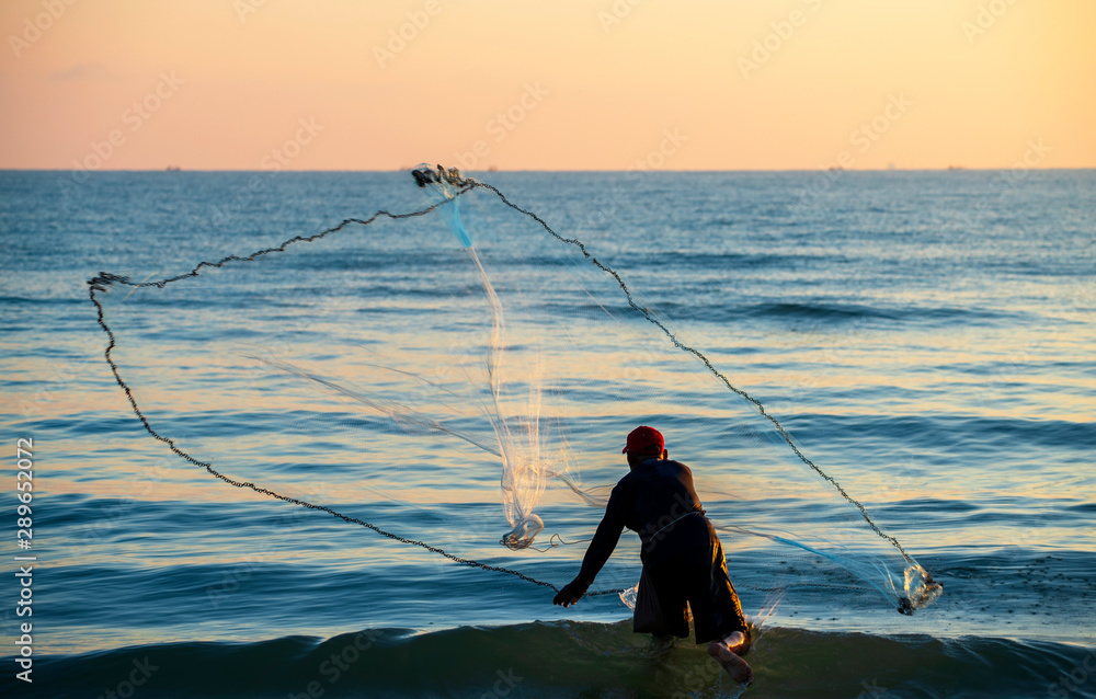 The fisherman cast a net the sea in the morning, at sunrise The fisherman cast a net the sea in the morning, at sunrise