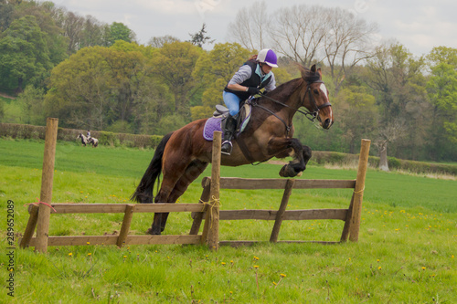 Horse and rider, tackling a large fence when out on a ride.