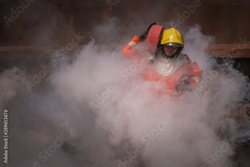 Firefighters training, Team practice to fighting with fire in emergency situation. A fireman carry a water hose run through flame