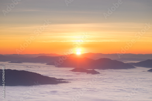 Dramatic sunset and sunrise over mountain sea of fog morning twilight evening sky.