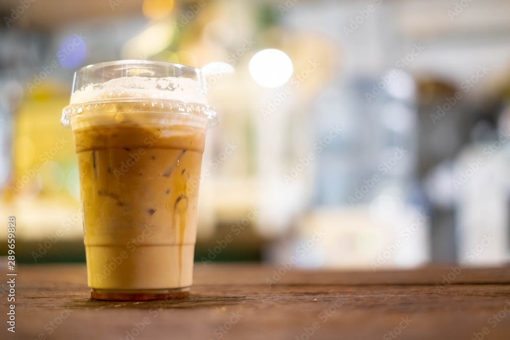 Ice cafe latte coffee the refreshment cold drink on wooden table with restaurant shop bokeh background. Ice cafe latte coffee the refreshment cold drink on wooden table with restaurant shop bokeh background.