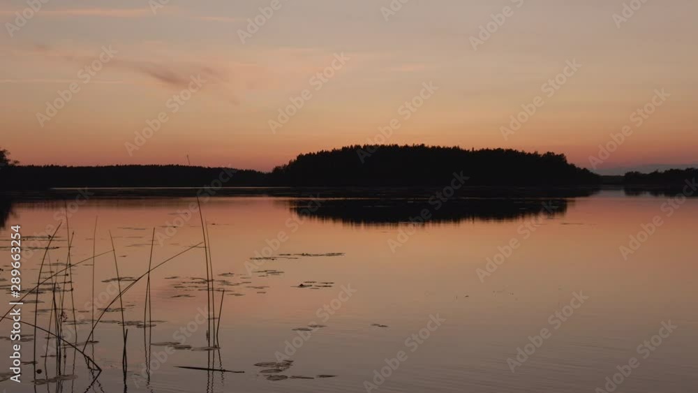 Sunset. Drone shot of landscape with lake and island. Golden sky and horizon. Sun, sky and clouds reflection in water. Wild nature. Sunset. Drone shot of landscape with lake and island. Golden sky and horizon. Sun, sky and clouds reflection in water. Wild nature.