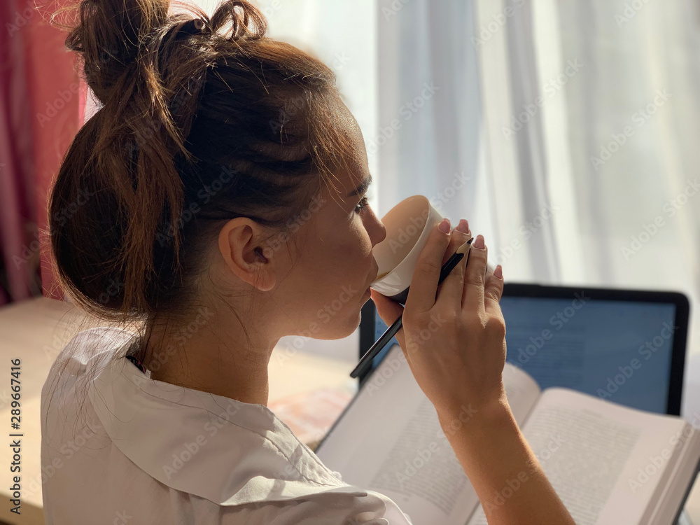 Fototapeta premium Girl drinks coffee in the office.