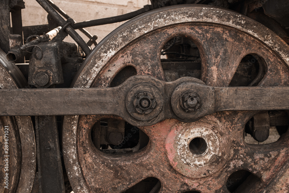 Closeup view of old rusty weather wheels of train standing outdoor. Horizontal color photography.