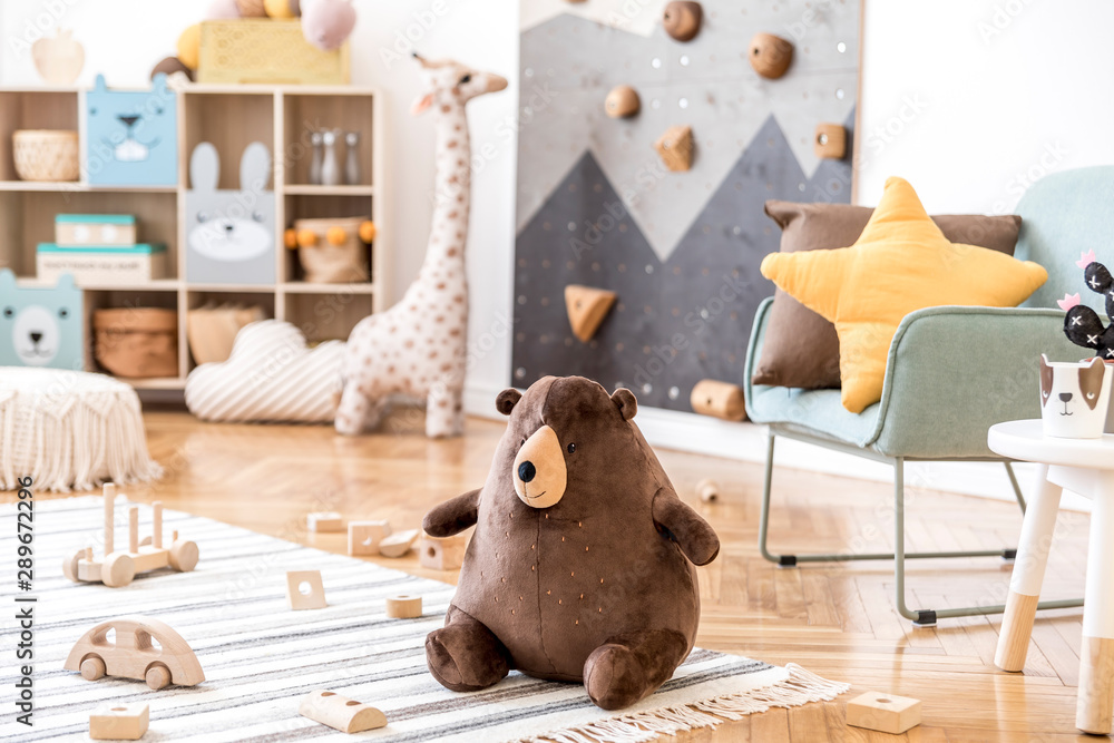 Modern scandinavian interior design of childroom with mint armchair, climbing wall for kids, design furnitures, soft toys, teddy bear and cute children's accessories. Stylish kidroom decor. Template. - obrazy, fototapety, plakaty 