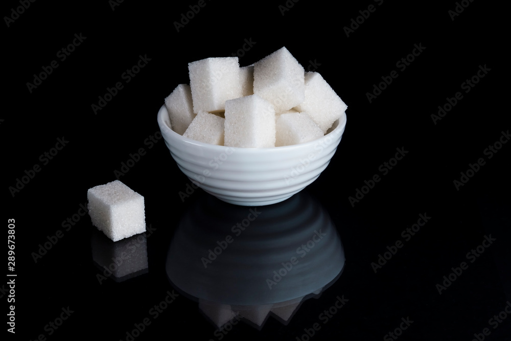 Sugar cubes in sugar bowl on black background Sugar cubes in sugar bowl on black background