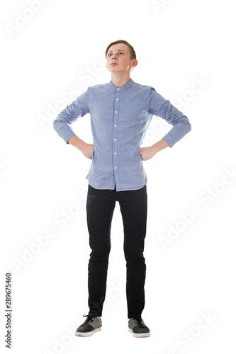 Full length portrait casual boy teenager posing hands on hips showing chest and power like a superhero isolated over white background. People confidence expression, strength and motivation concept. photo