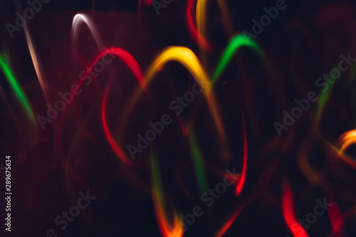 Neon multicolor glowing curvy lines. Blur lights. Dark abstract art background.