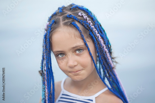 Portrait of a girl with dreadlocks on a light background photo