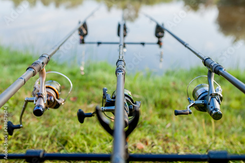 Closeup of a reel fishing rod on a prop and water background