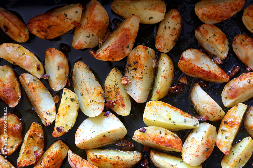 Baked potatoes seasoned with onion, basil and smoked paprika. Top view. Baked potatoes seasoned with onion, basil and smoked paprika. Top view.