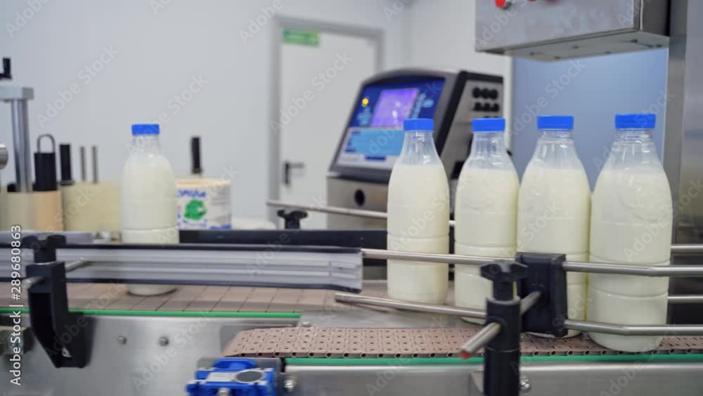 Automated company for packaging milk. Plastic bottles with fresh white milk on a conveyor belt. Modernized dairy plant. Automated company for packaging milk. Plastic bottles with fresh white milk on a conveyor belt. Modernized dairy plant.
