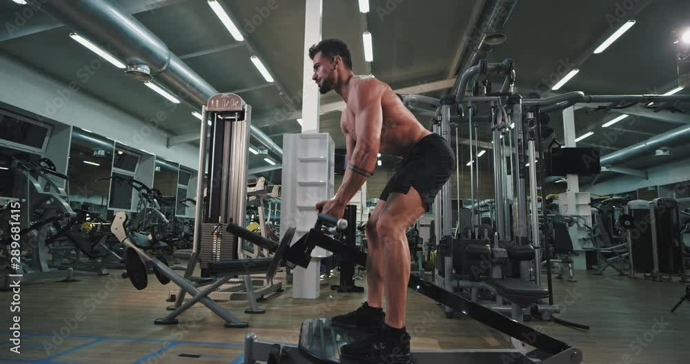 Large gym class good looking man exercises hard to make more muscle lifting up the weights Large gym class good looking man exercises hard to make more muscle lifting up the weights