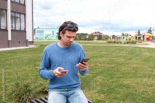 Man is typing a messages on two mobile phones