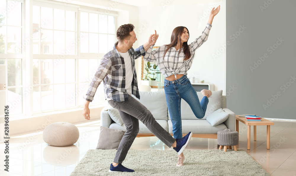 Fototapeta premium Happy young couple dancing at home