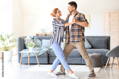Happy dancing couple at home