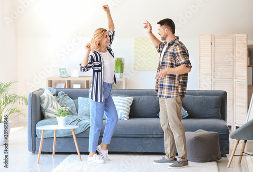 Happy dancing couple at home