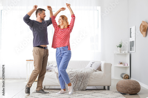 Happy dancing couple at home