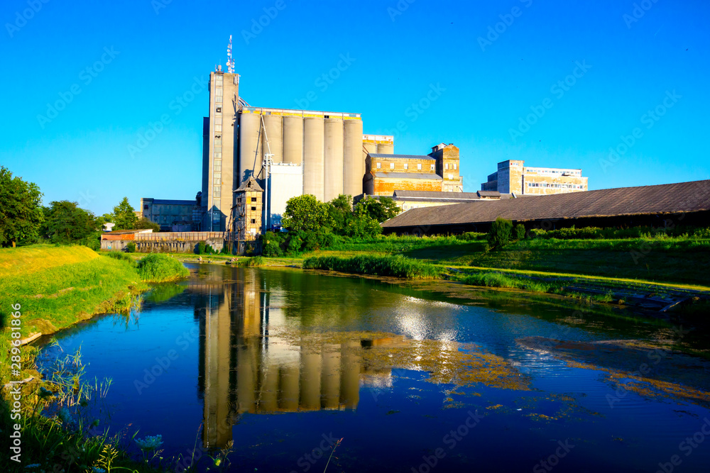 Big and old concrete grain silos by the lake