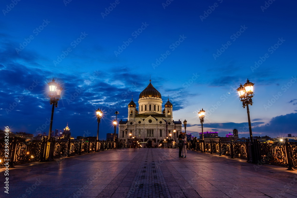 Obraz premium Illuminated Cathedral of Christ the Savior framed with old style street lights of Patriarchy Bridge at night.