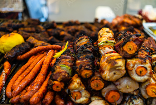 Juicy steaming meat on a charcoal grill, pork steaks, chicken breast, sausages, pieces of meat chops at a street food festival