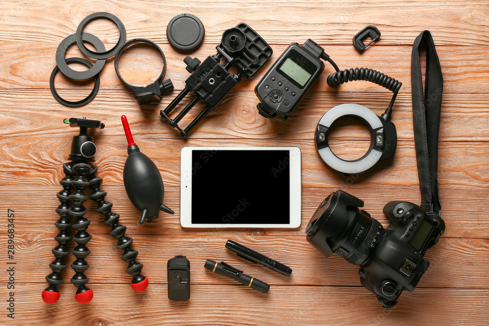 Modern tablet computer with photographer's equipment on wooden background Modern tablet computer with photographer's equipment on wooden background