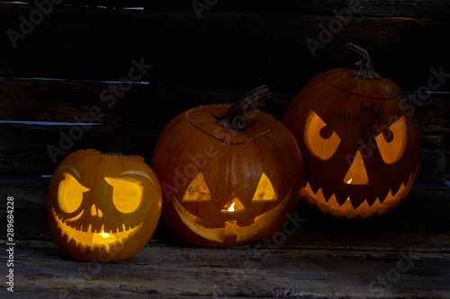 Halloween pumpkin head jack lanterns. Jack O Lanterns Halloween pumpkin face on wooden background. Halloween holiday celebration.