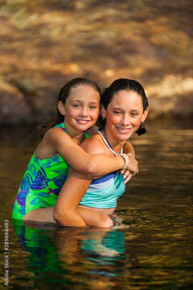 Fototapeta premium Two sisters swimming in a stream in Stowe, Vermont
