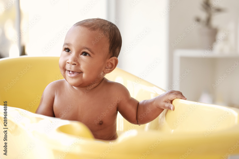 Little African-American baby washing in bathtub at home Little African-American baby washing in bathtub at home