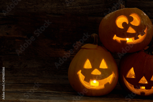 Halloween pumpkins with funny expression. Carved Halloween pumpkin with lights inside on a black background. Celebration of Halloween.