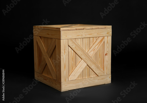 One closed wooden crate on black background