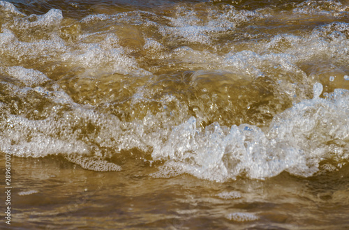Wild seashore of the Baltic Sea with foam waves.