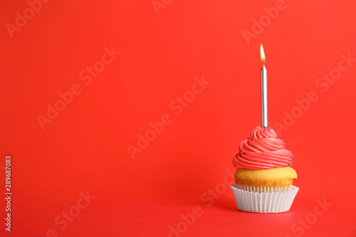 Birthday cupcake with candle on red background, space for text