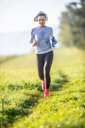 Young sporty woman running in nature. Morning training sportswoman