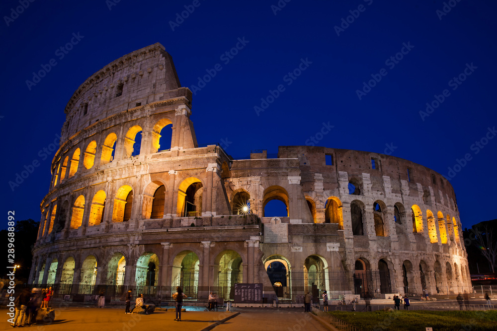 Tourists visiting the famous Colosseum at night in Rome