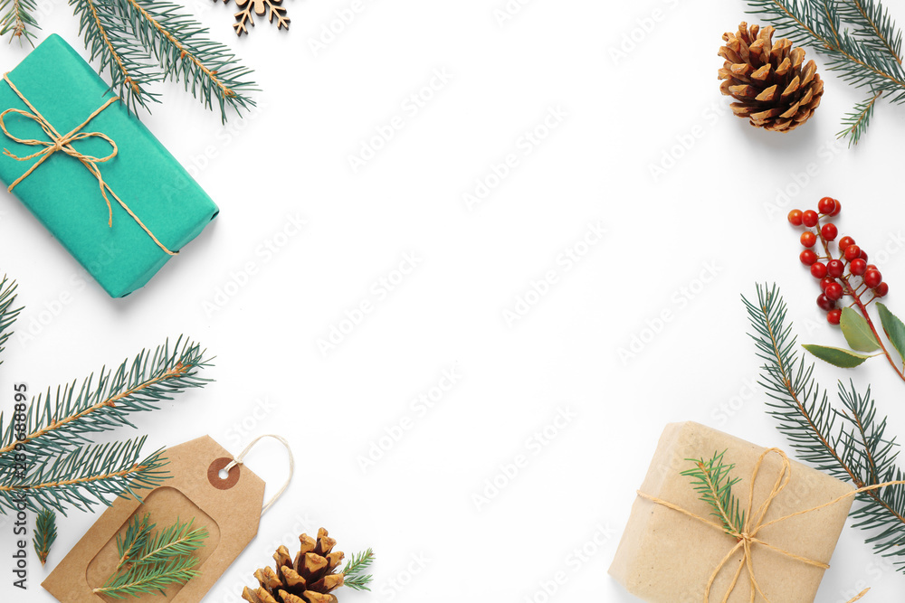 Fototapeta premium Flat lay composition with Christmas gifts and festive decor on white background. Space for text
