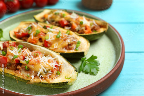 Delicious stuffed zucchini served on light blue wooden table  closeup