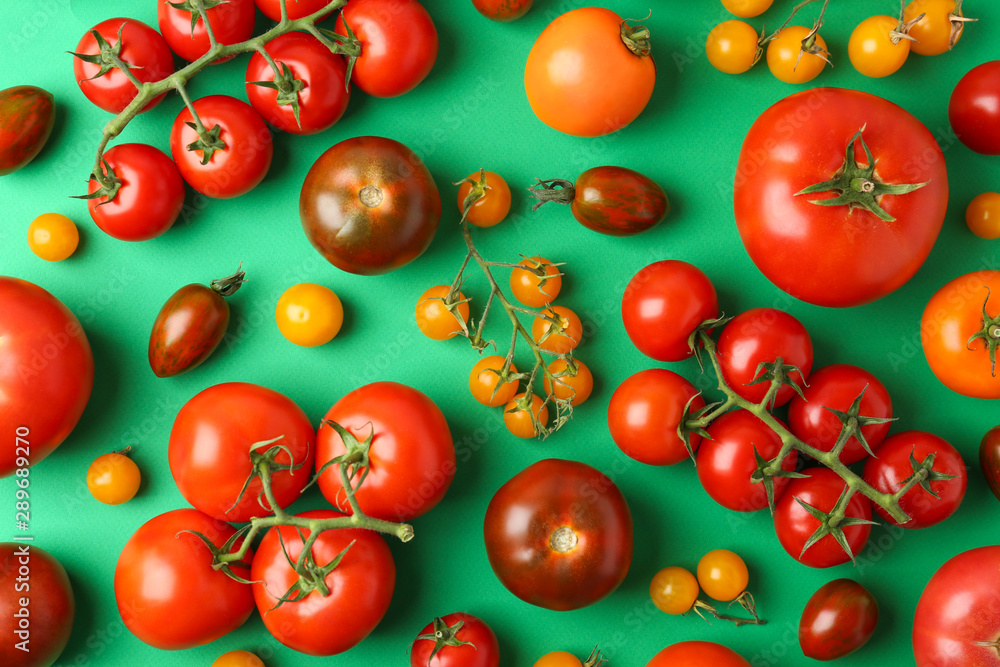 Flat lay composition with fresh ripe tomatoes on green background Flat lay composition with fresh ripe tomatoes on green background
