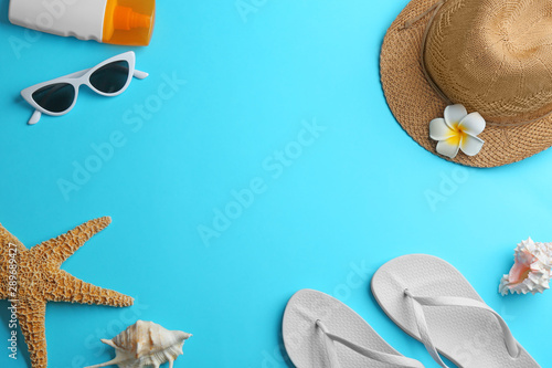 Frame made with beach accessories on light blue background, flat lay. Space for text