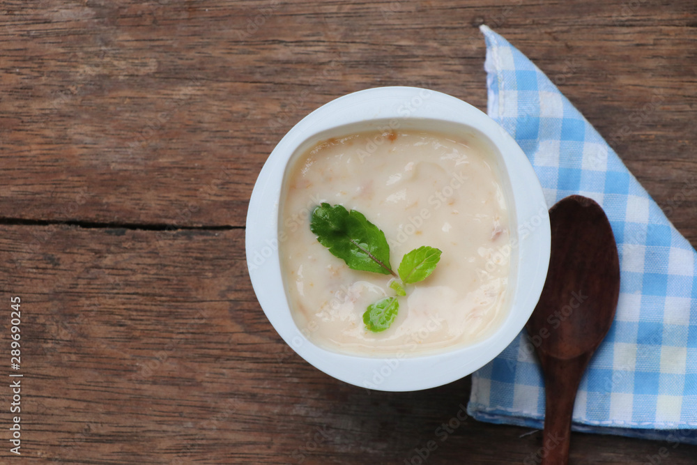 Prune yogurt with pepper mint topping good healthy and delicious in plastic glass on wood table background Prune yogurt with pepper mint topping good healthy and delicious in plastic glass on wood table background
