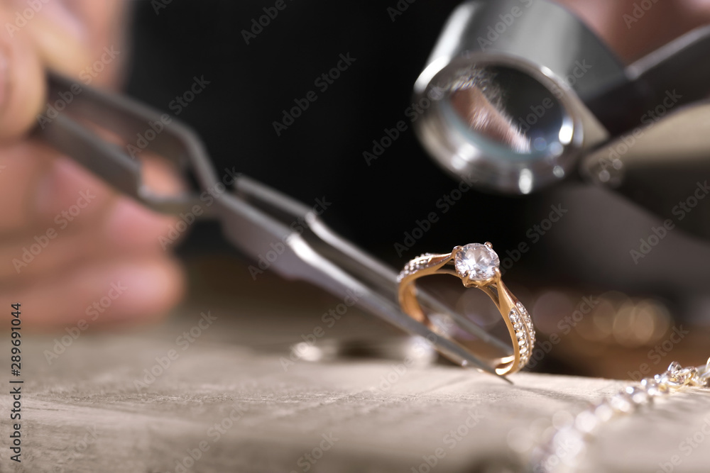 Male jeweler examining diamond ring in workshop, closeup view - obrazy, fototapety, plakaty 