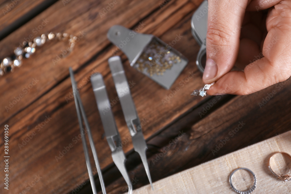 Male jeweler evaluating diamond ring in workshop, closeup view Male jeweler evaluating diamond ring in workshop, closeup view