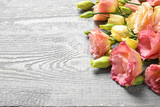 Beautiful fresh Eustoma flowers on wooden table, space for text